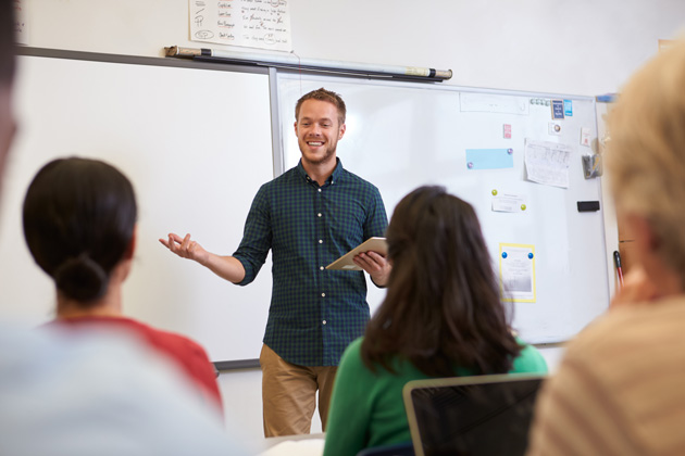 Lehrer spricht vor einer Gruppe von Lehramtstudenten